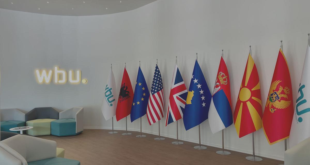 Main lobby with the illuminated “wbu.” sign and a row of national flags